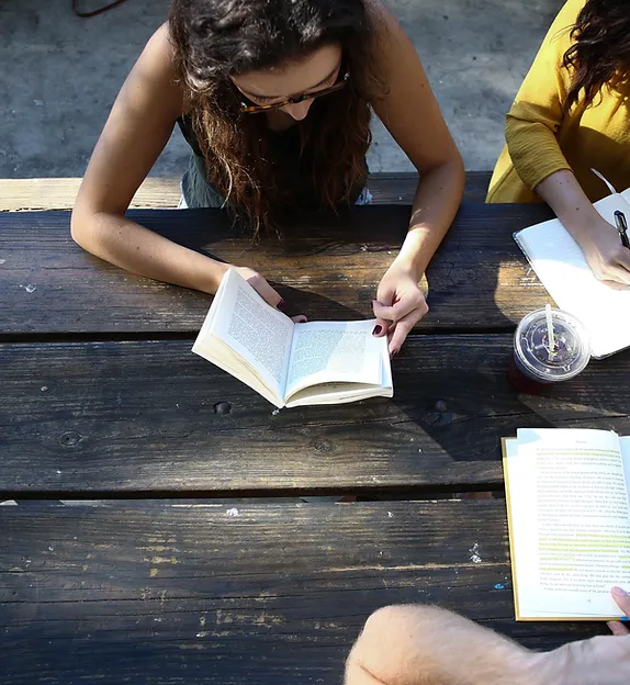 TREC Home page Supervision & Consultation - two young people sitting on a bench reading and reviewing