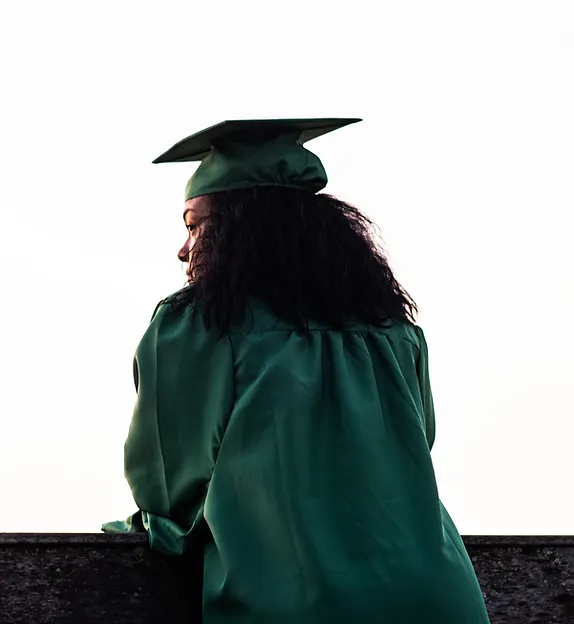 TREC DC Training Programs - Young African American lady wearing a green graduation gown and graduation cap